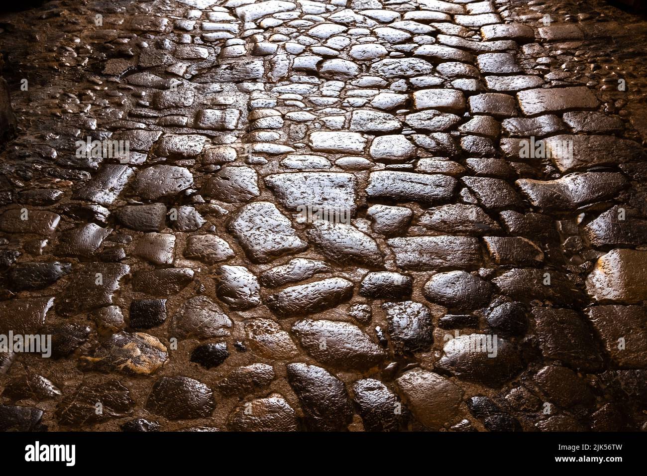 Ancien pavé romain aux pierres lisses, fond et texture. Banque D'Images