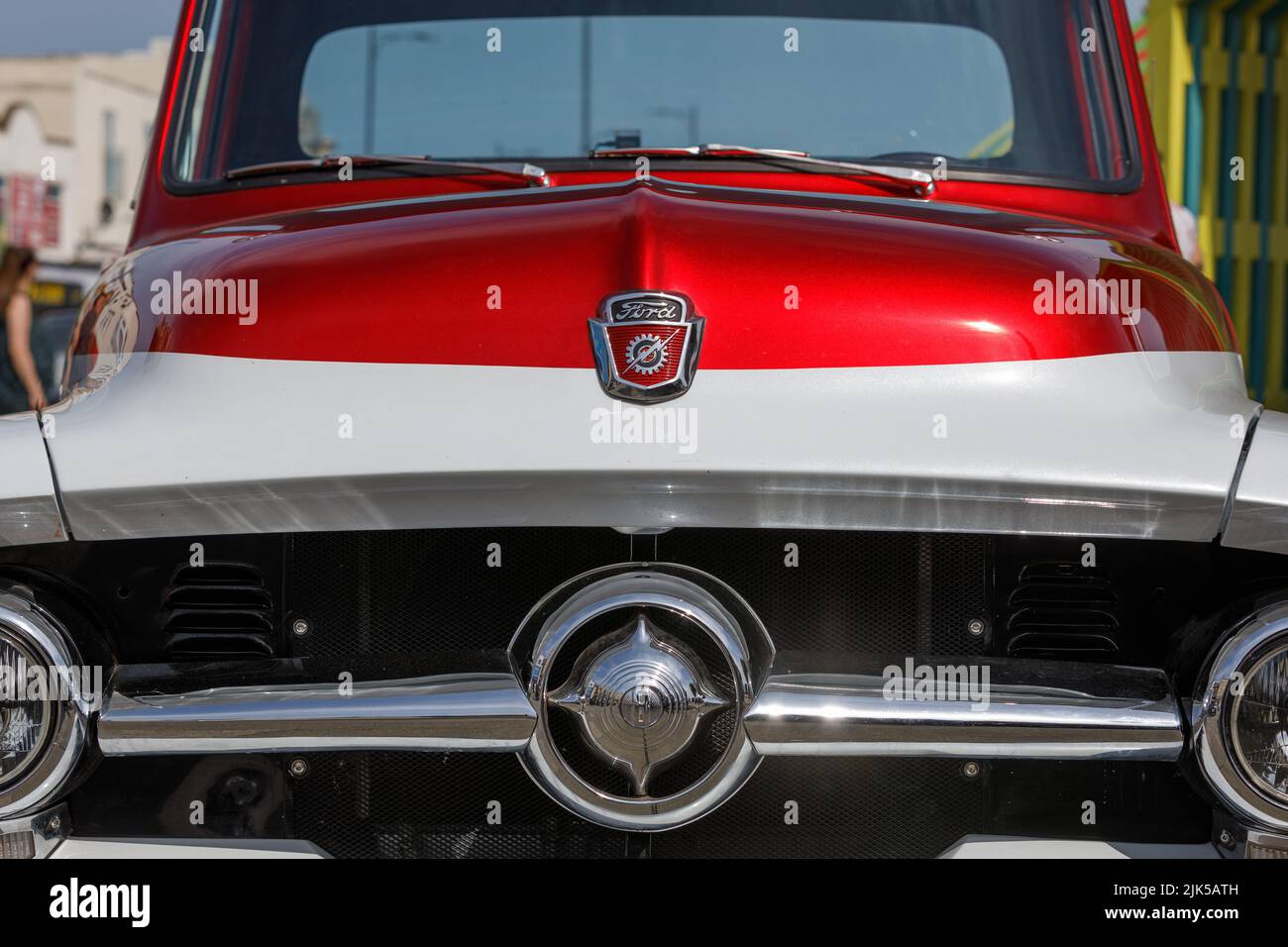 Un camion de pick-up personnalisé Ford F100 des années 1950 en rouge et blanc. Vue avant de l'aile, du capot, de l'emblème et du pare-brise. Banque D'Images