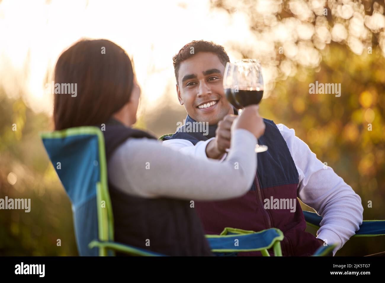 Campez plus de soucis moins. Un jeune couple ayant un verre dehors tout en campant dehors. Banque D'Images