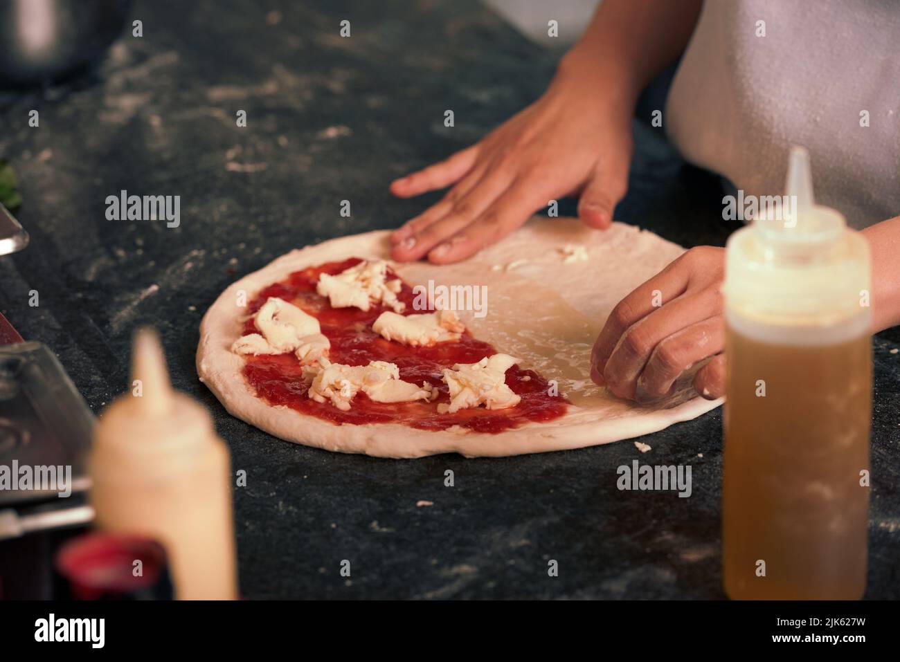 Gros plan sur la pizza préparée par un cuisinier dans la cuisine du café Banque D'Images