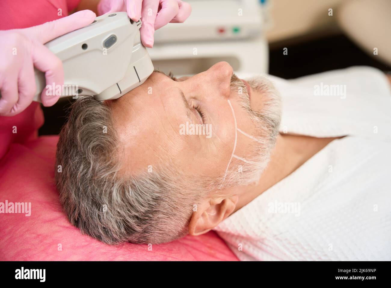 Les mains des femmes dermatologues font de l'homme l'échographie