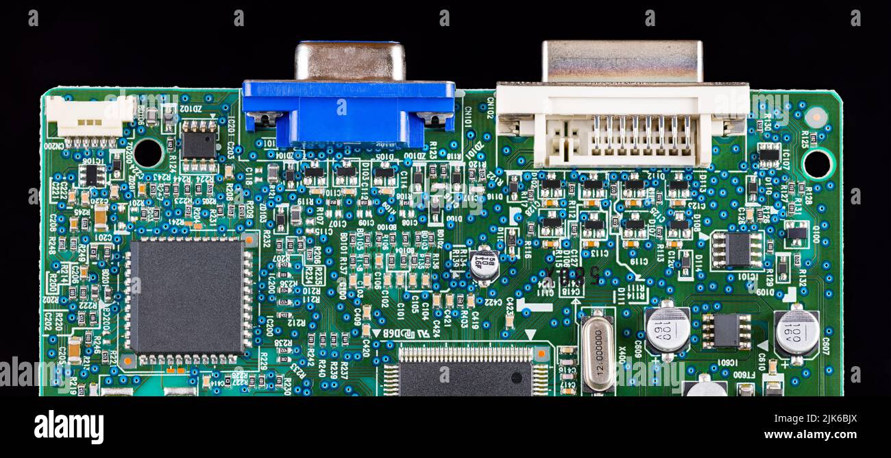 Détail de carte de circuit imprimé vert isolé sur fond panoramique noir. Divers composants électroniques comme puce, transistor ou cristal. Périphériques à montage en surface. Banque D'Images