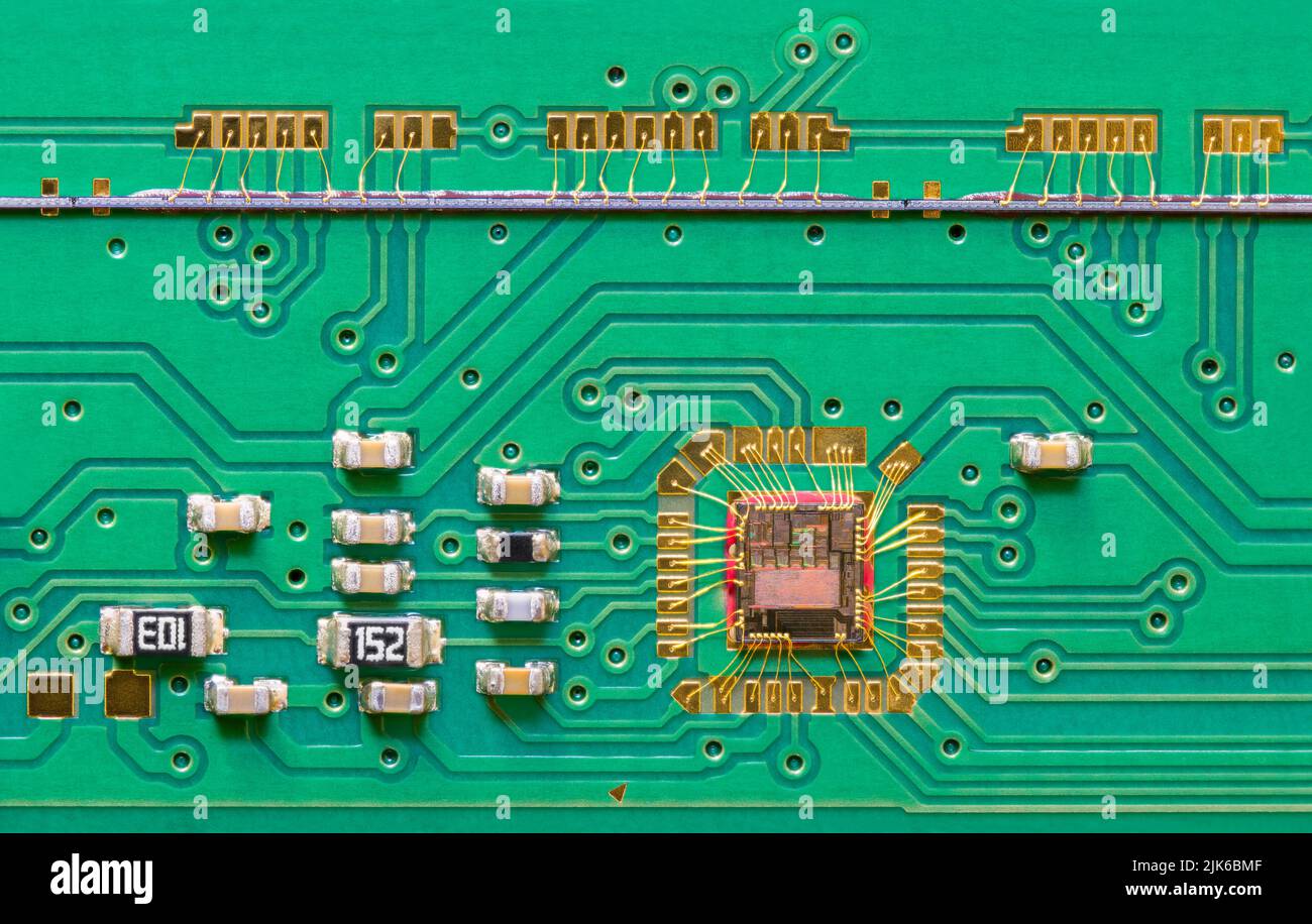 Matrice de circuit intégrée câblée à la texture de carte imprimée verte avec caméra de balayage de ligne. Gros plan de la puce collée par des fils dorés à la carte de circuit imprimé à l'intérieur du scanner à plat. Banque D'Images