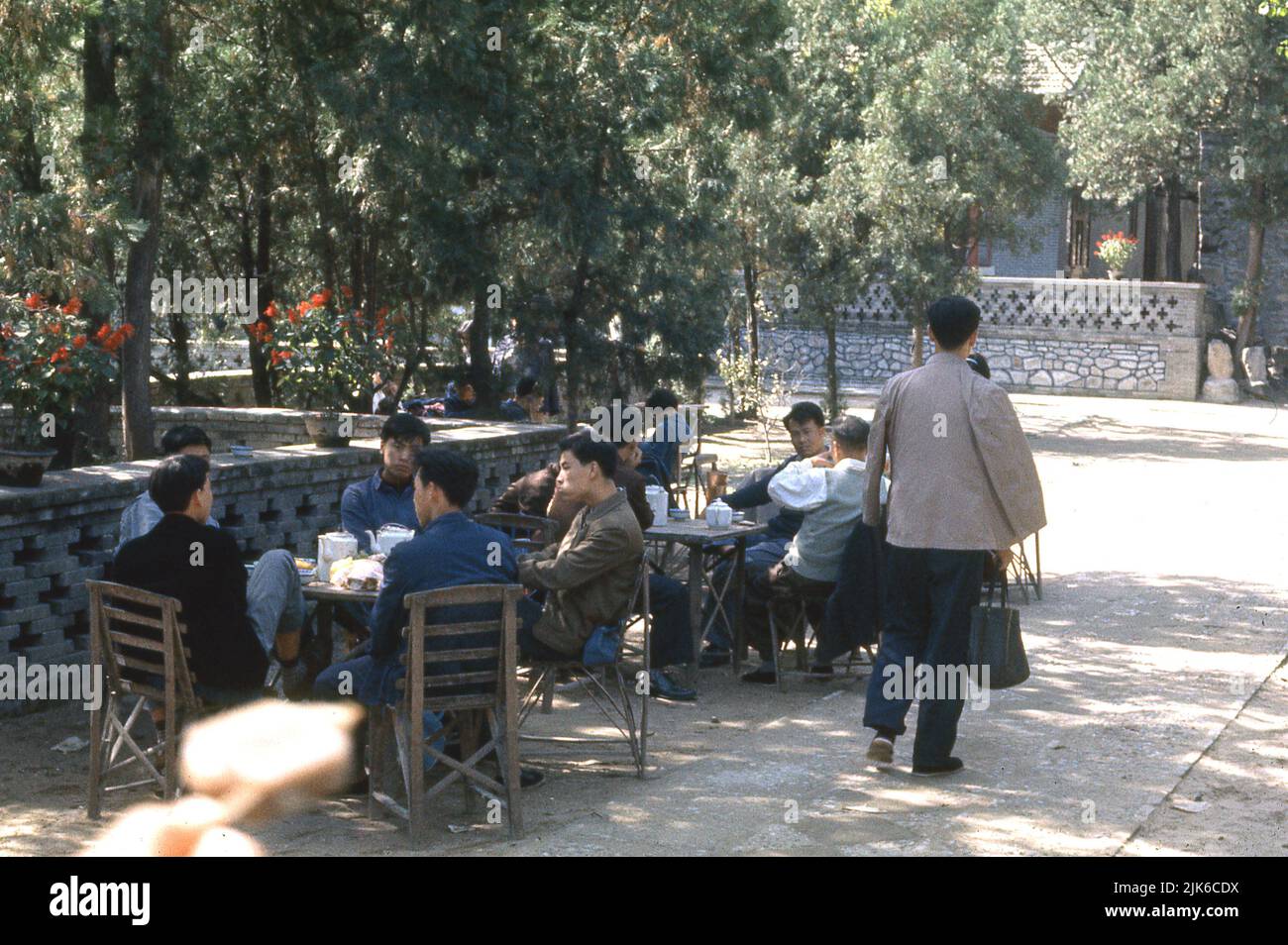 1972, historique, les jeunes hommes chinois ont une tasse de thé assis autour d'une table à l'extérieur dans les collines occidentales, Pékin, Chine. Les collines et les montagnes sont une zone pittoresque de la ville et un lieu établi utilisé par les érudits chinois et les disciples religieux comme une retraite, avec des jardins botaniques et des temples. Banque D'Images