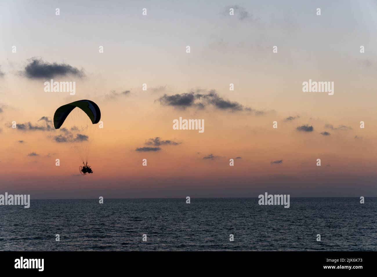 Les hommes volent sur le parachute au soleil Banque D'Images