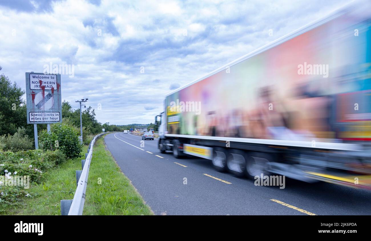Camion passant le panneau de la frontière défacé entre la République d'Irlande et l'Irlande du Nord, Belfast-Dublin Road Banque D'Images