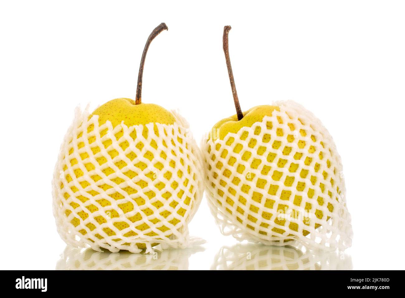Deux poires bio jaune vif dans un paquet, en gros plan, isolées sur fond blanc. Banque D'Images