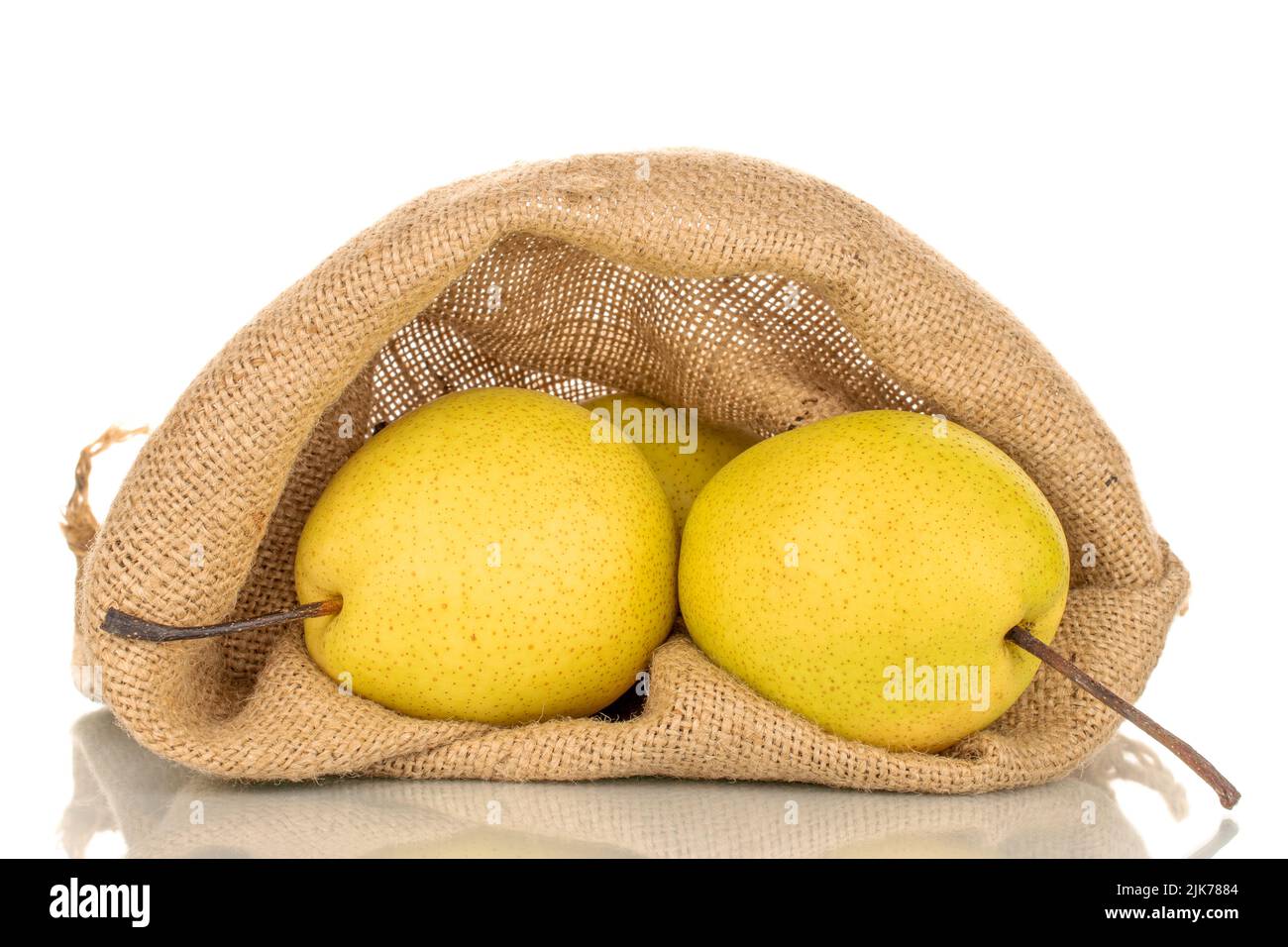 Deux poires bio jaune vif dans un sac de jute, en gros plan, isolées sur un fond blanc. Banque D'Images