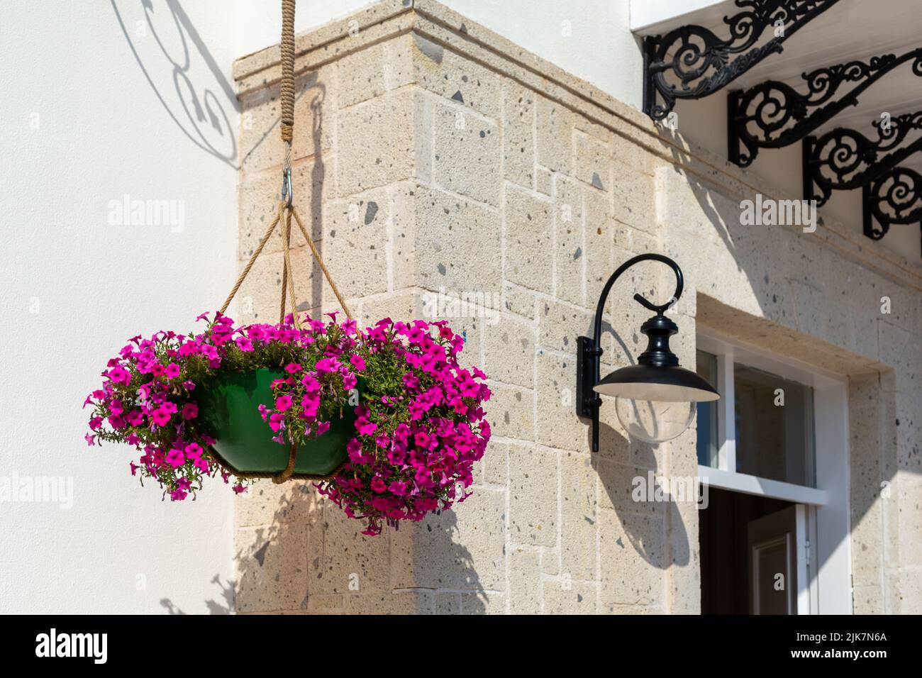 Panier de bougainvilliers accroché à un mur de pierre Banque D'Images