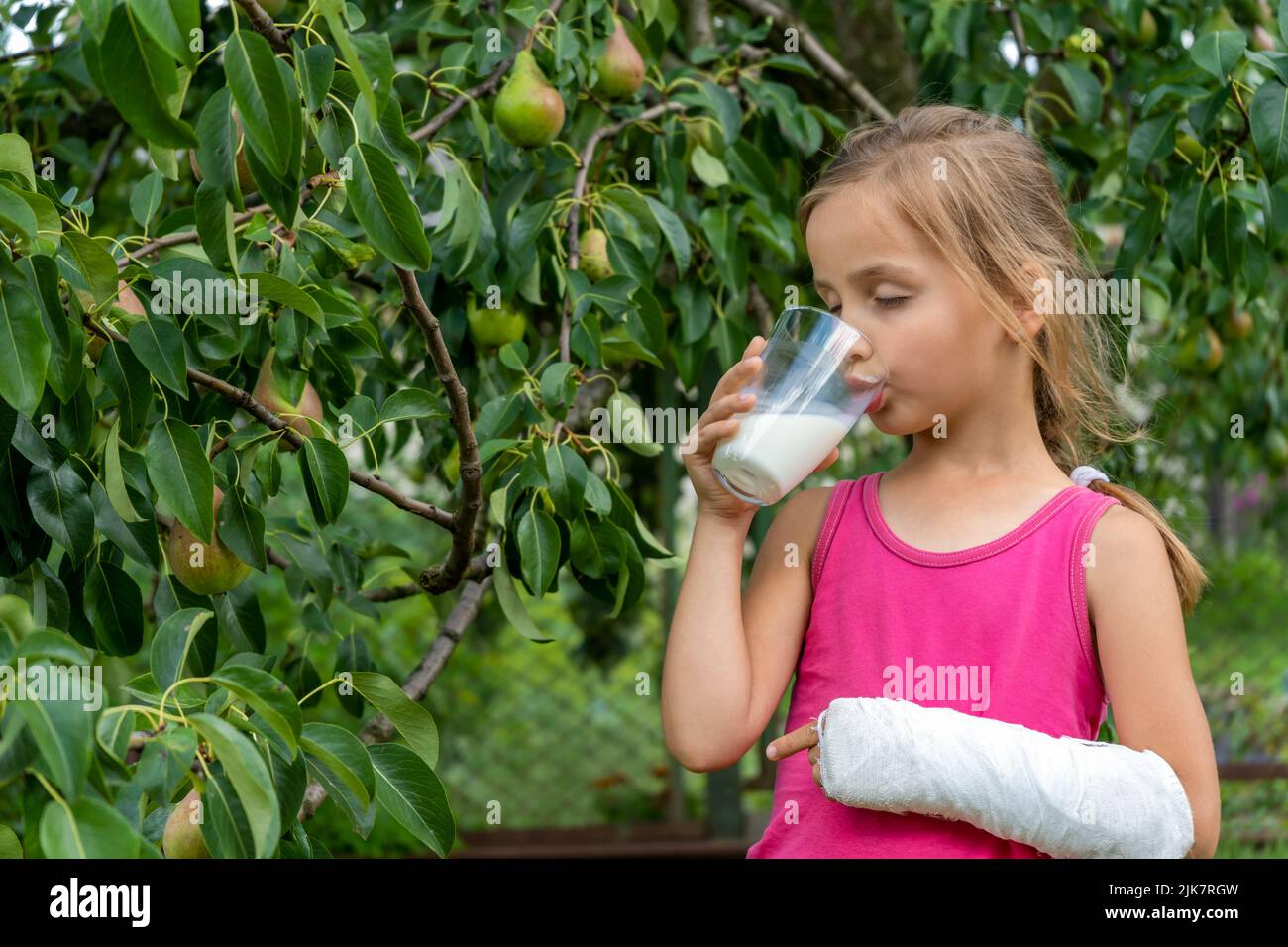 Petite fille mignonne avec un bras cassé dans un lait de boisson moulé Banque D'Images