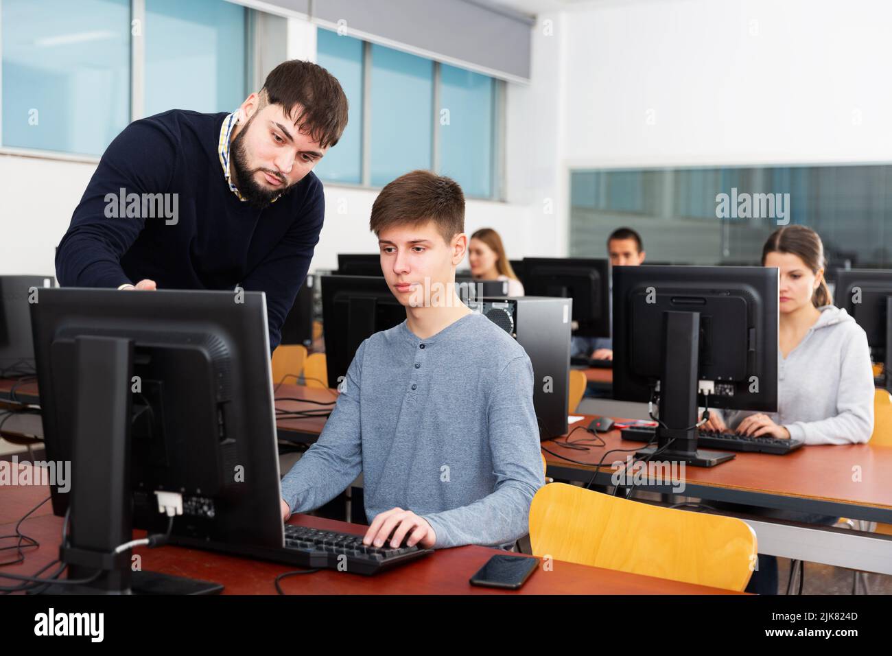 Enseignant aidant jeune étudiant Banque D'Images