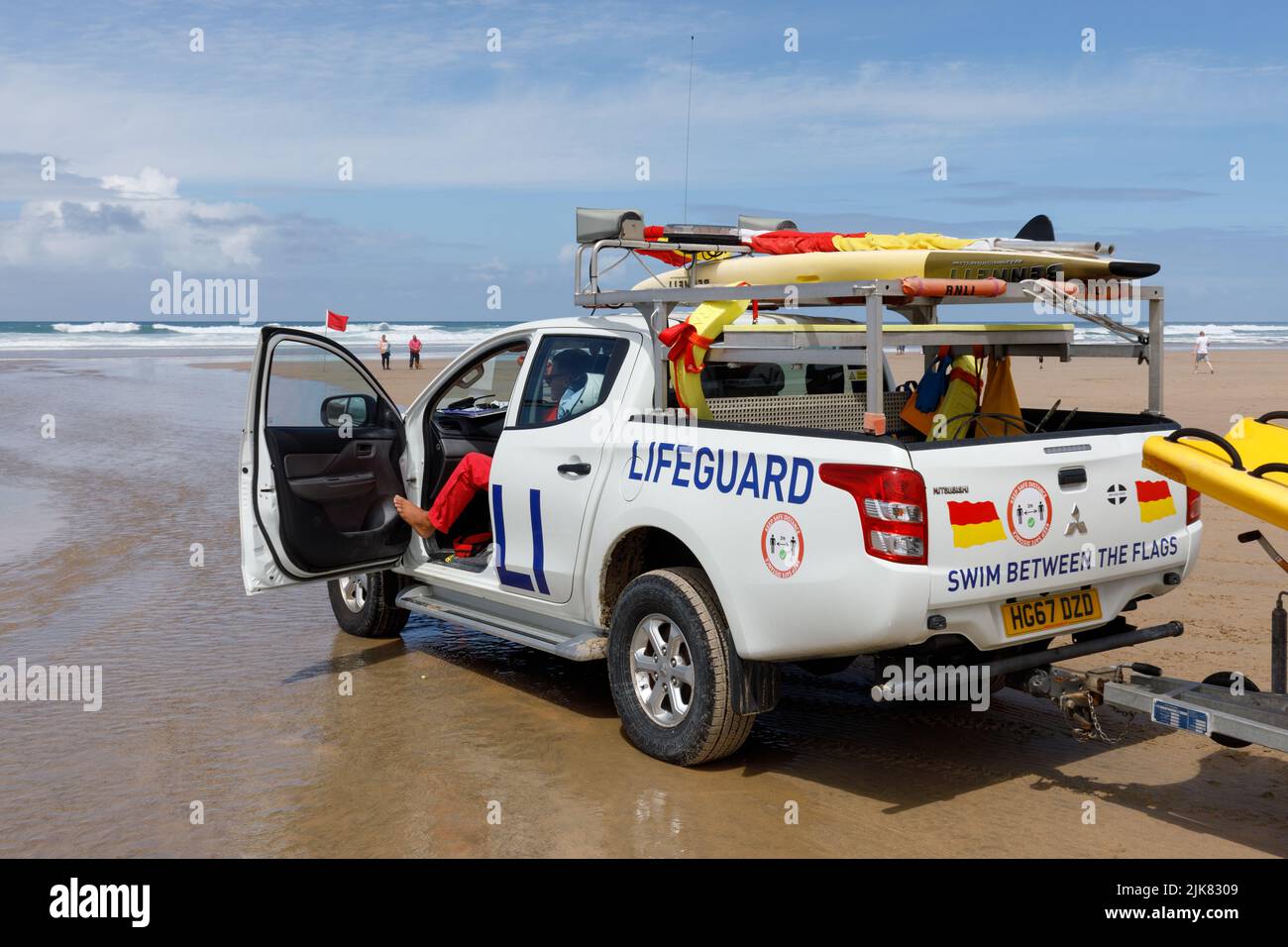 Un camion de patrouille RNLI Surf Rescue Lifeguard se trouve sur la plage, à l'écoute des usagers de la plage et des nageurs en détresse. Banque D'Images