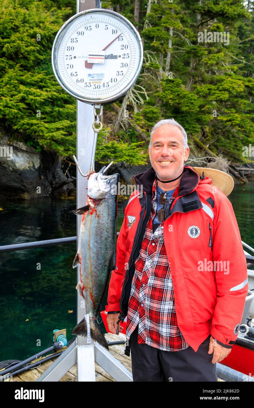 Île Langara, Colombie-Britannique, Canada - 30 mai 2022 : pêcheur touristique pesant la prise du jour sur la marina et le quai de la Loge de pêche Langara l Banque D'Images