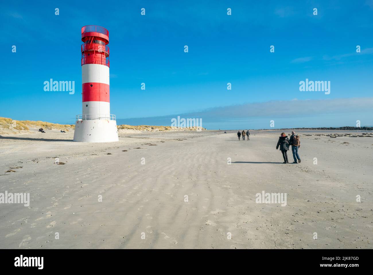 Dune et Heligoland, Allemagne - 02.27.2022: Personnes marchant autour du phare et grand groupe de phoques gris sur la plage de l'île de Dune, Heligoland sur un Banque D'Images