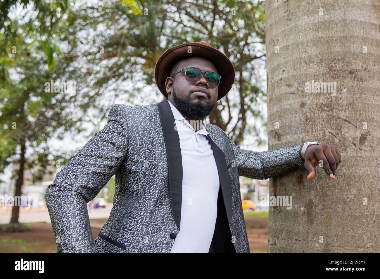 Un jeune homme africain réfléchi pose dans son parc de la ville. Concept de solitude. Banque D'Images