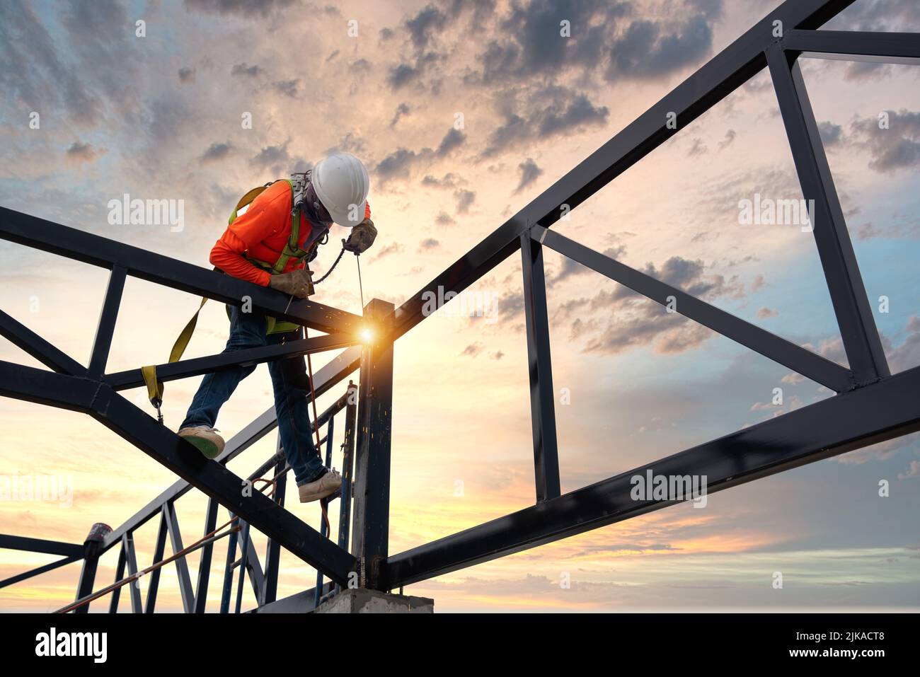 A soudeurs sur les zones à risque. Soudeurs de treillis de toit en acier avec dispositifs de sécurité pour empêcher les chutes d'une hauteur sur le chantier de construction. Banque D'Images