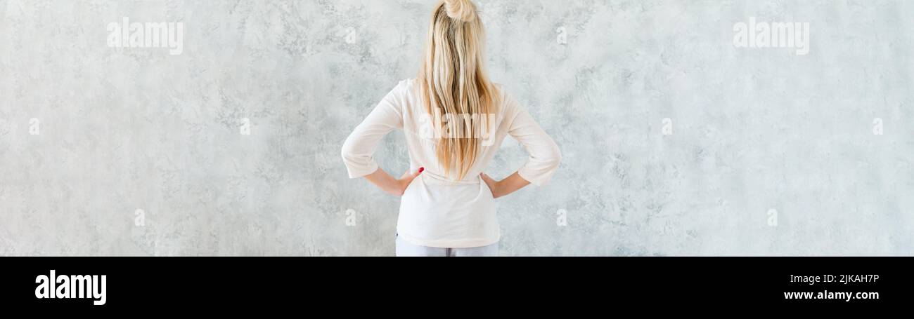décoration intérieure blonde femme mains hanches vue arrière Banque D'Images