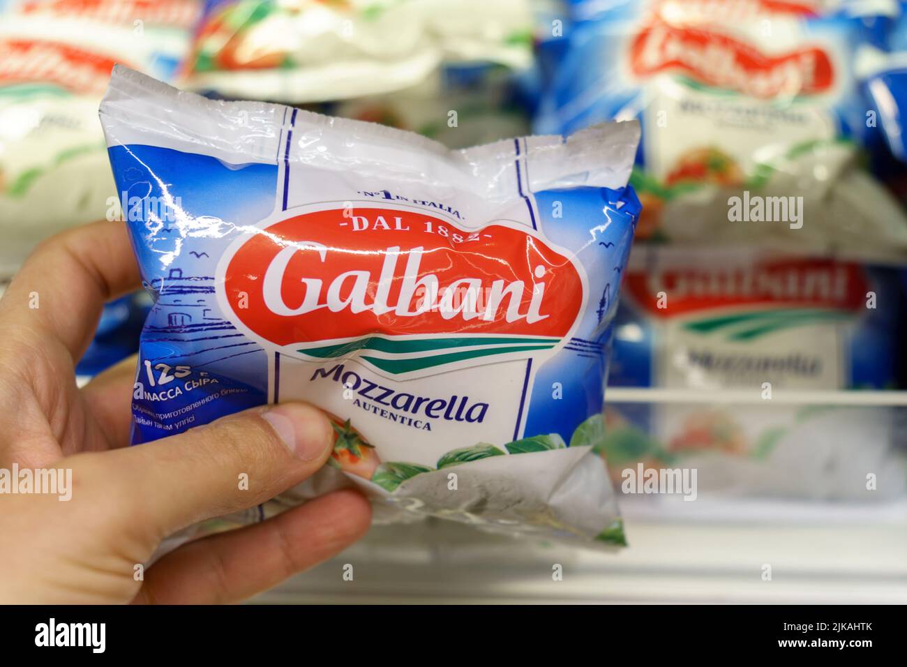 Tyumen, Russia-26 mai 2022: Homme main tenant le paquet avec délicieux Galbani Mozzarella au supermarché Banque D'Images