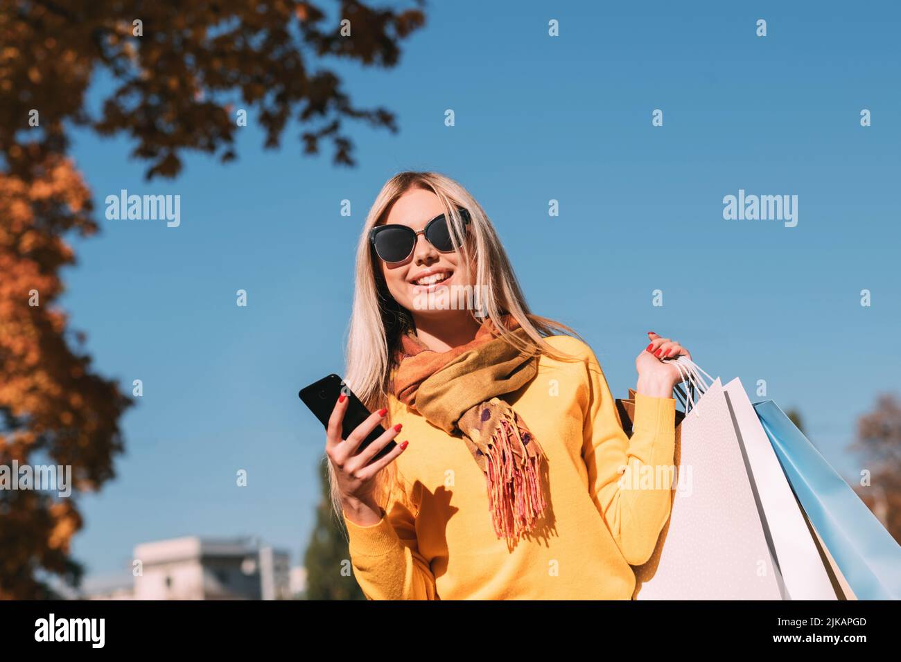 fall park walk shopping bags smartphone chat Banque D'Images