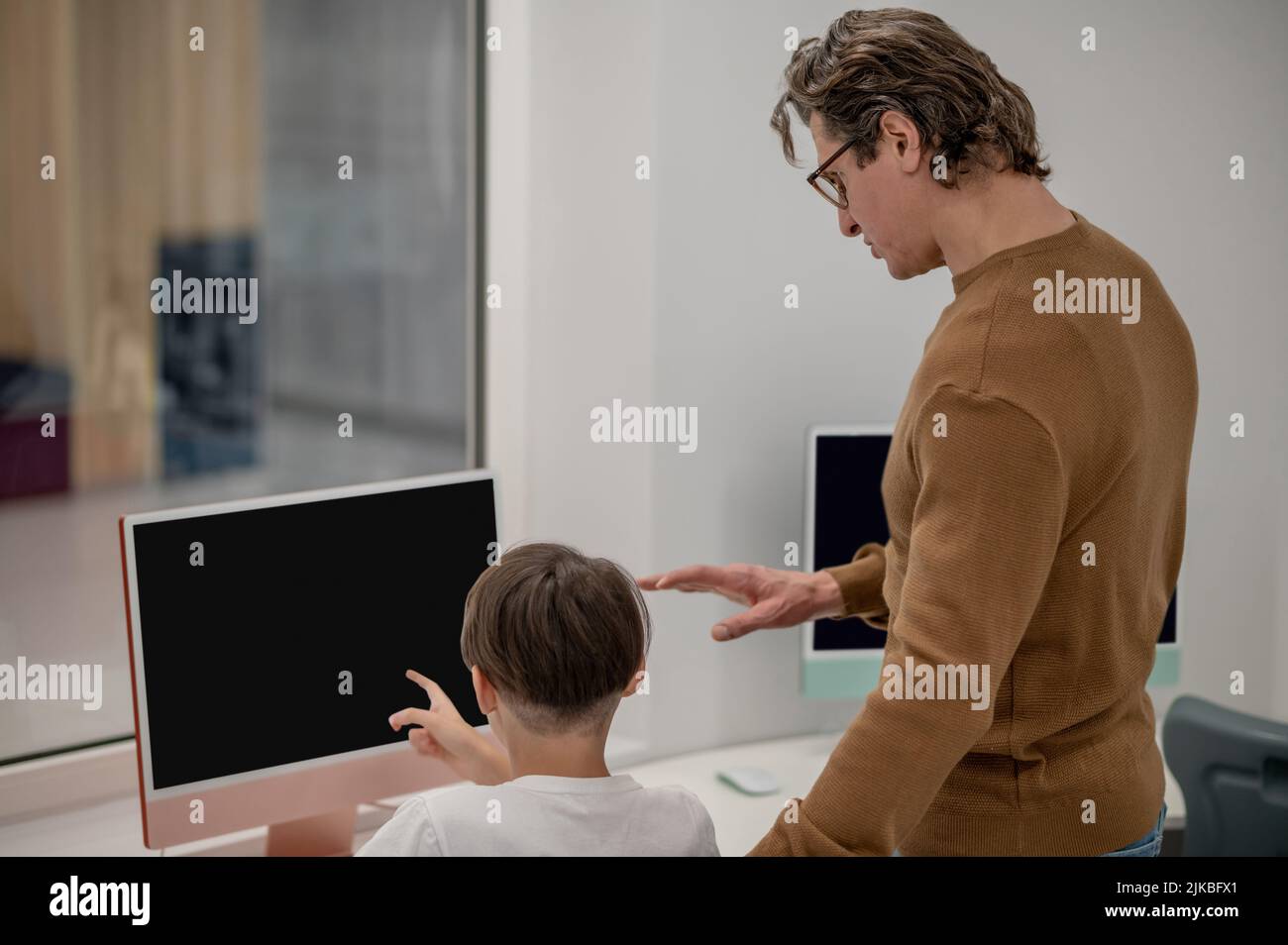 Les écoliers et leur enseignant aux ordinateurs dans une salle de classe Banque D'Images