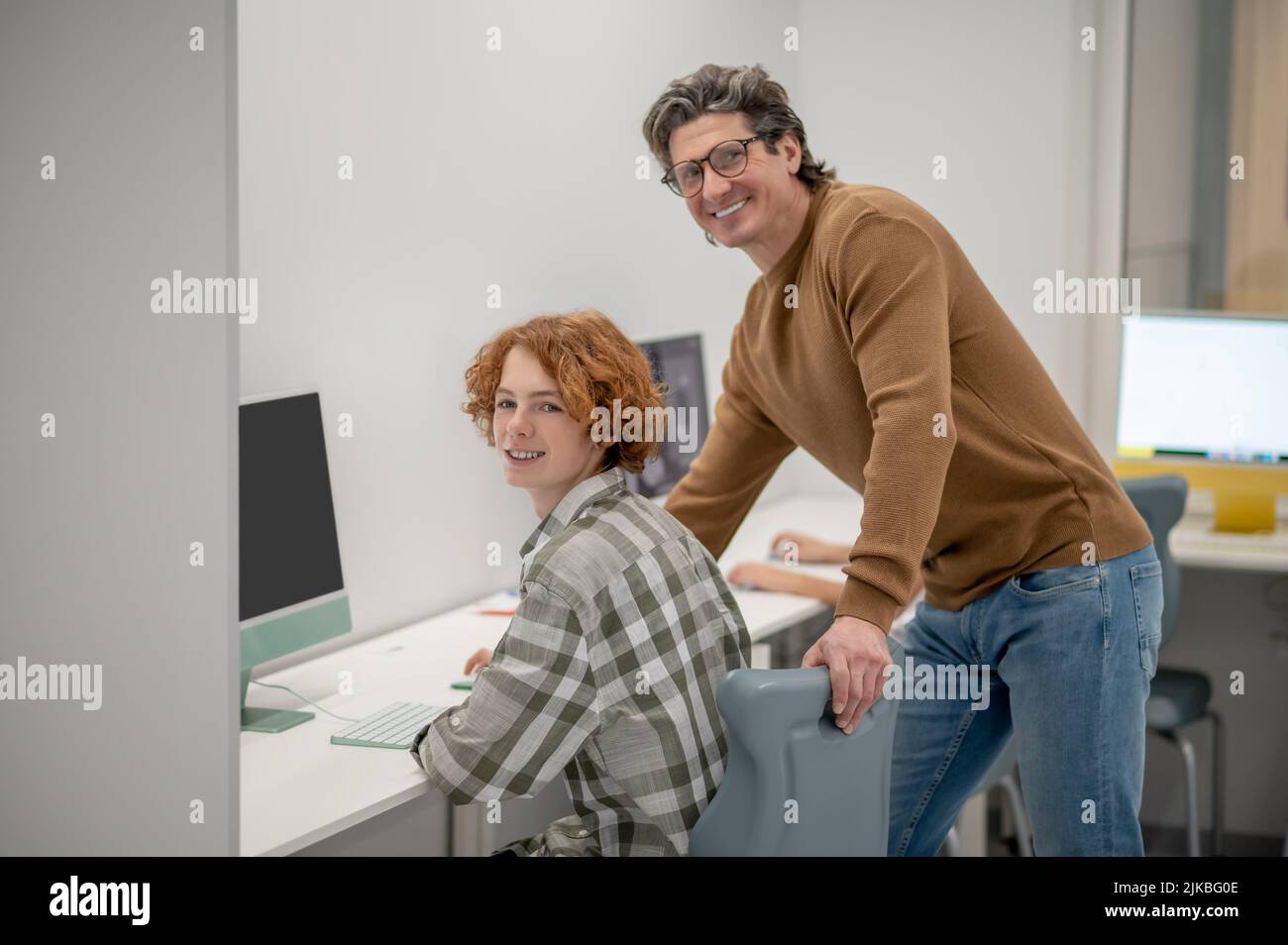Les écoliers et leur enseignant aux ordinateurs dans une salle de classe Banque D'Images