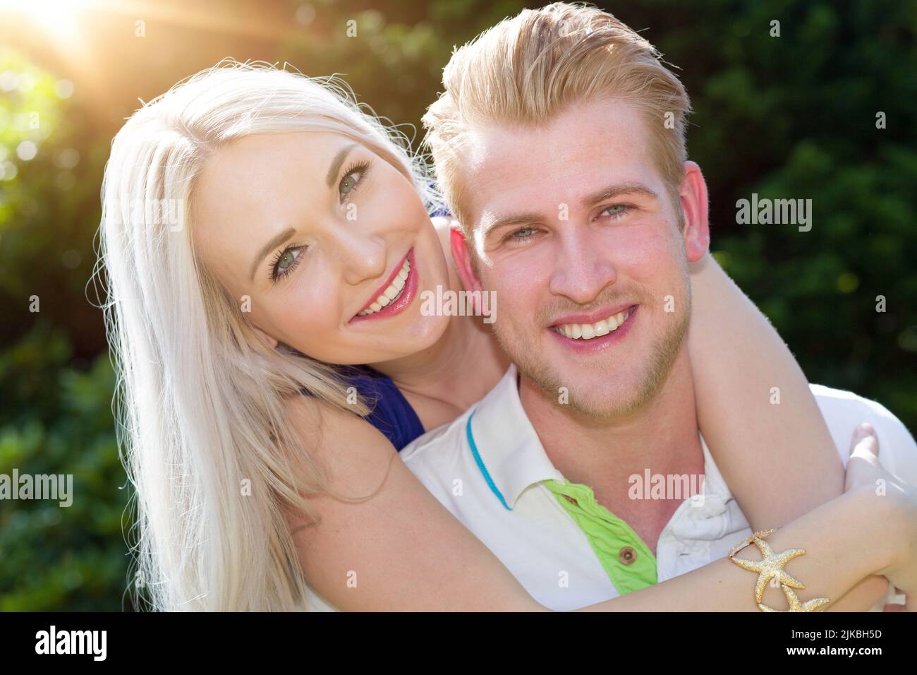 Un jeune et heureux couple plein d'amour ensemble à l'extérieur au soleil Banque D'Images