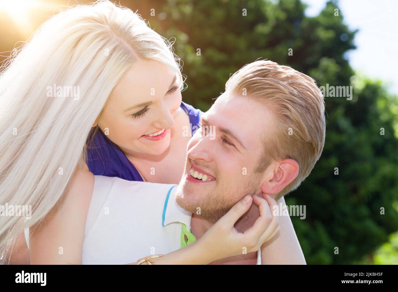 Un jeune et heureux couple plein d'amour ensemble à l'extérieur au soleil Banque D'Images