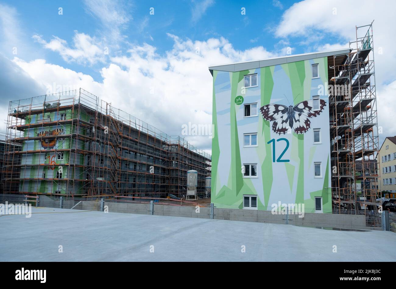deux immeubles modernes, dont l'un est doté d'un échafaudage en façade, artistiquement conçu avec un motif de formes polygonales, symbolisant l'orme floral Banque D'Images