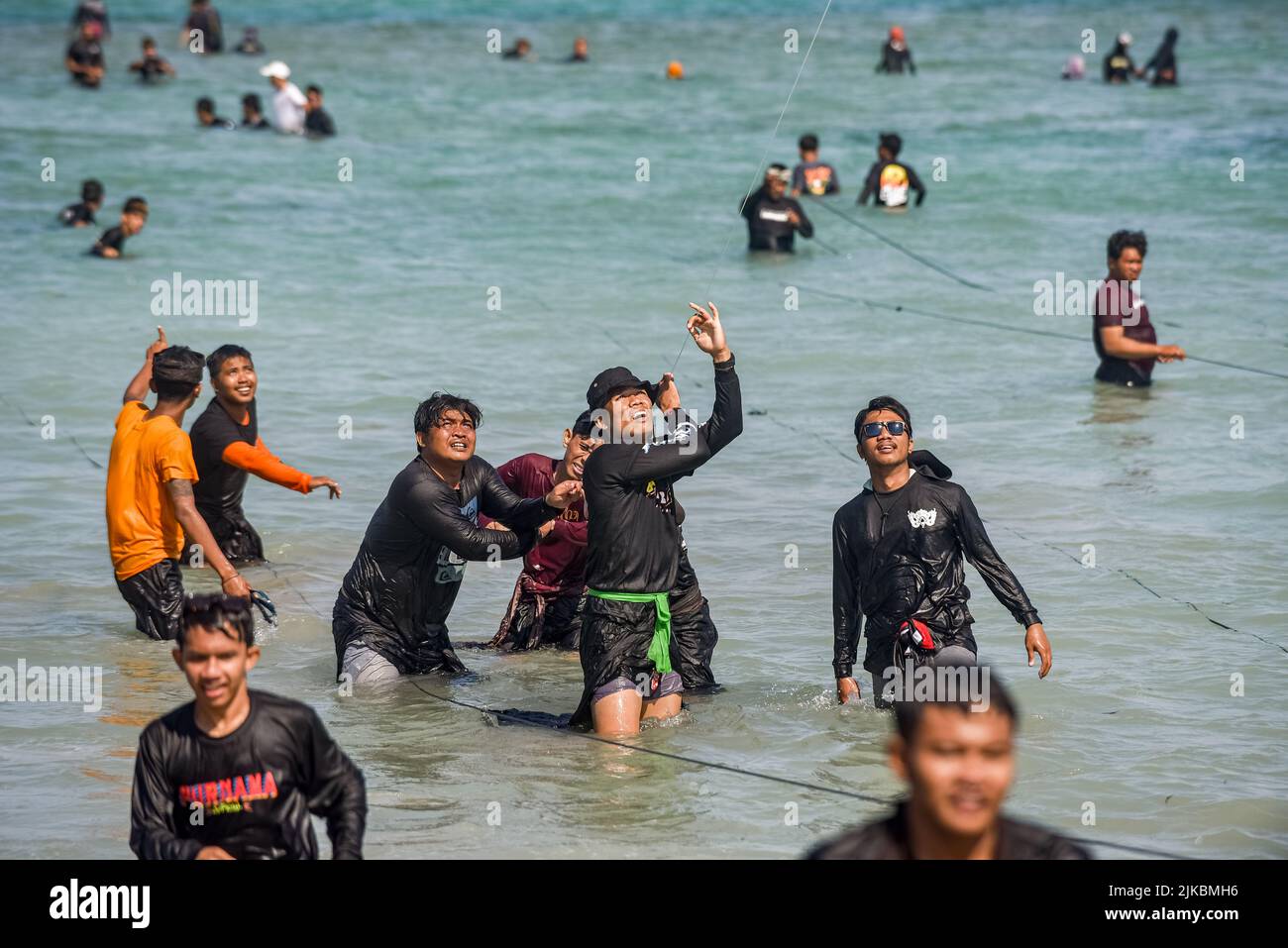 Denpasar, Indonésie. 31st juillet 2022. Les participants tirent une chaîne de cerf-volant de la mer. Des milliers de personnes affluent à Mertasari Beach à Sanur pour un festival de cerf-volant pendant la saison de cerf-volant de Bali, qui s'étend de mai à septembre chaque année, entre la saison sèche. Le festival est le meilleur moment de l'année pour visiter Bali. Les couleurs rouge, blanc, noir et jaune-or représentent les incarnations des divinités hindoues balinaises. (Photo de Dicky Bisinglasi/SOPA Images/Sipa USA) crédit: SIPA USA/Alay Live News Banque D'Images