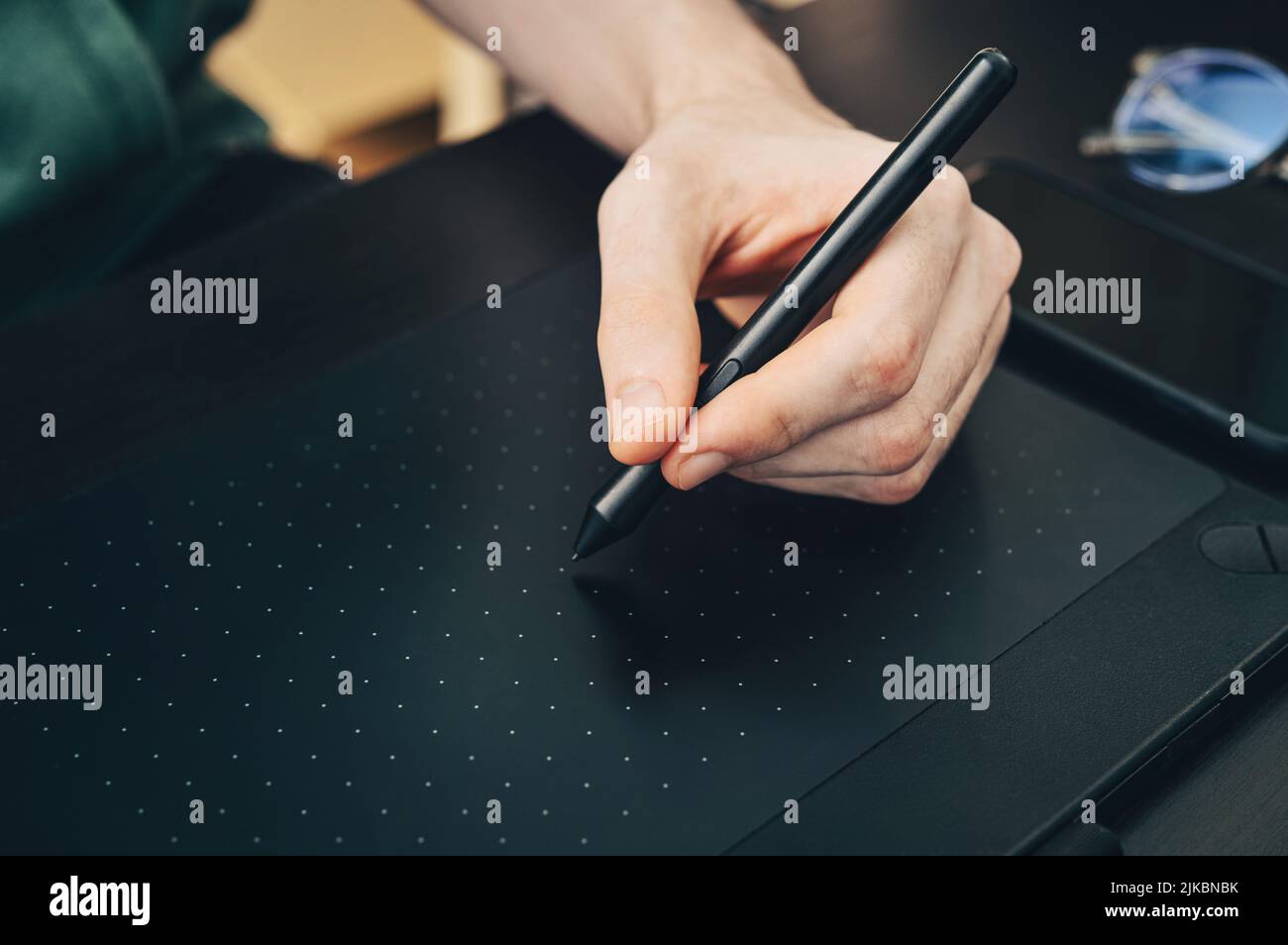 Jeune graphiste homme utilisant la tablette graphique sur table noire à la maison bureau de fermer. Banque D'Images