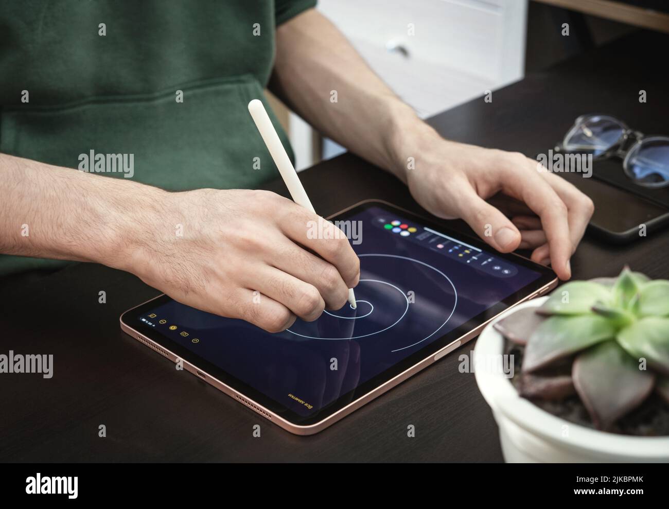 KIEV, UKRAINE - 21 DÉCEMBRE 2021:Man with Apple Pencil using iPad Pro for drawing. IPad Pro a été créé et développé par Apple inc Banque D'Images