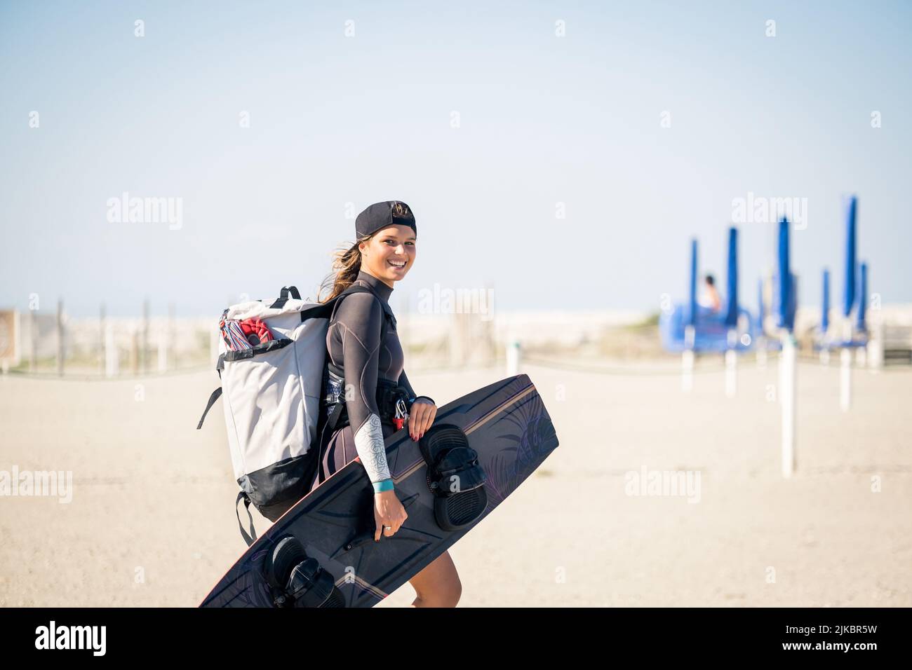 Belle fille souriante et vient à la plage avec équipement de kitesurf - Sporty femme concept et sport dur Banque D'Images