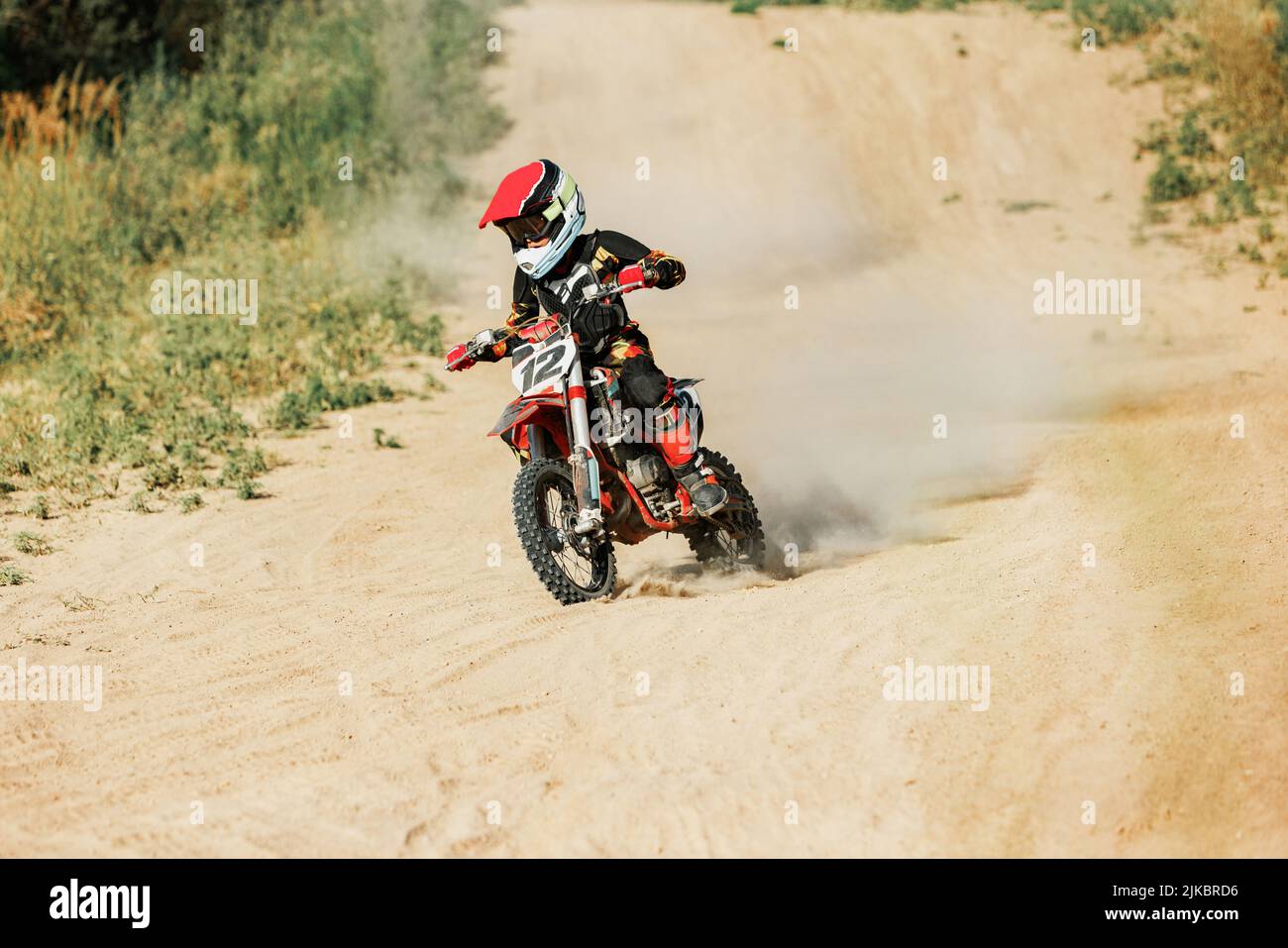 Prise de vue en direct d'un sportif junior, entraînement d'un motocycliste à moto par une chaude journée d'été, en plein air. Pilote de motocross en action. Sport de motocross, défis Banque D'Images