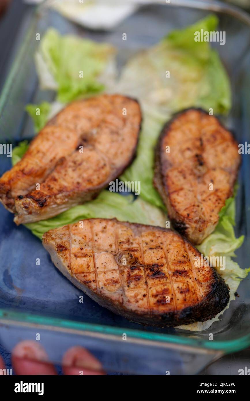 Mise au point sélective. Poisson grillé, steak de saumon grillé avec épices et légumes sur la plaque du gril à l'extérieur, vue de dessus, gros plan. Fruits de mer grillés Banque D'Images
