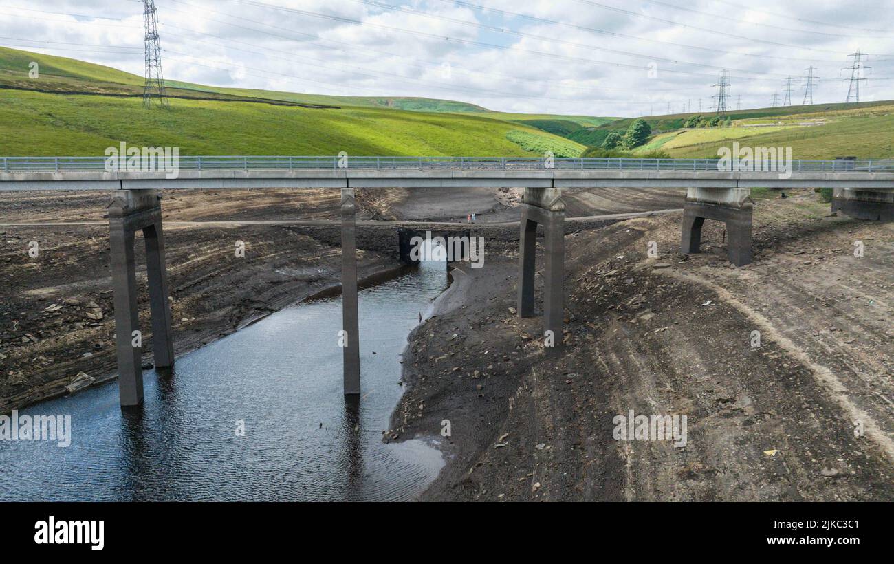 Les restes d'un vieux pont qui est normalement submergé sous l'eau sont exposés à plein comme l'eau dans le réservoir est gravement épuisée au réservoir Baitings près de Ripponden West Yorkshire, Royaume-Uni le 01/08/2022 Banque D'Images