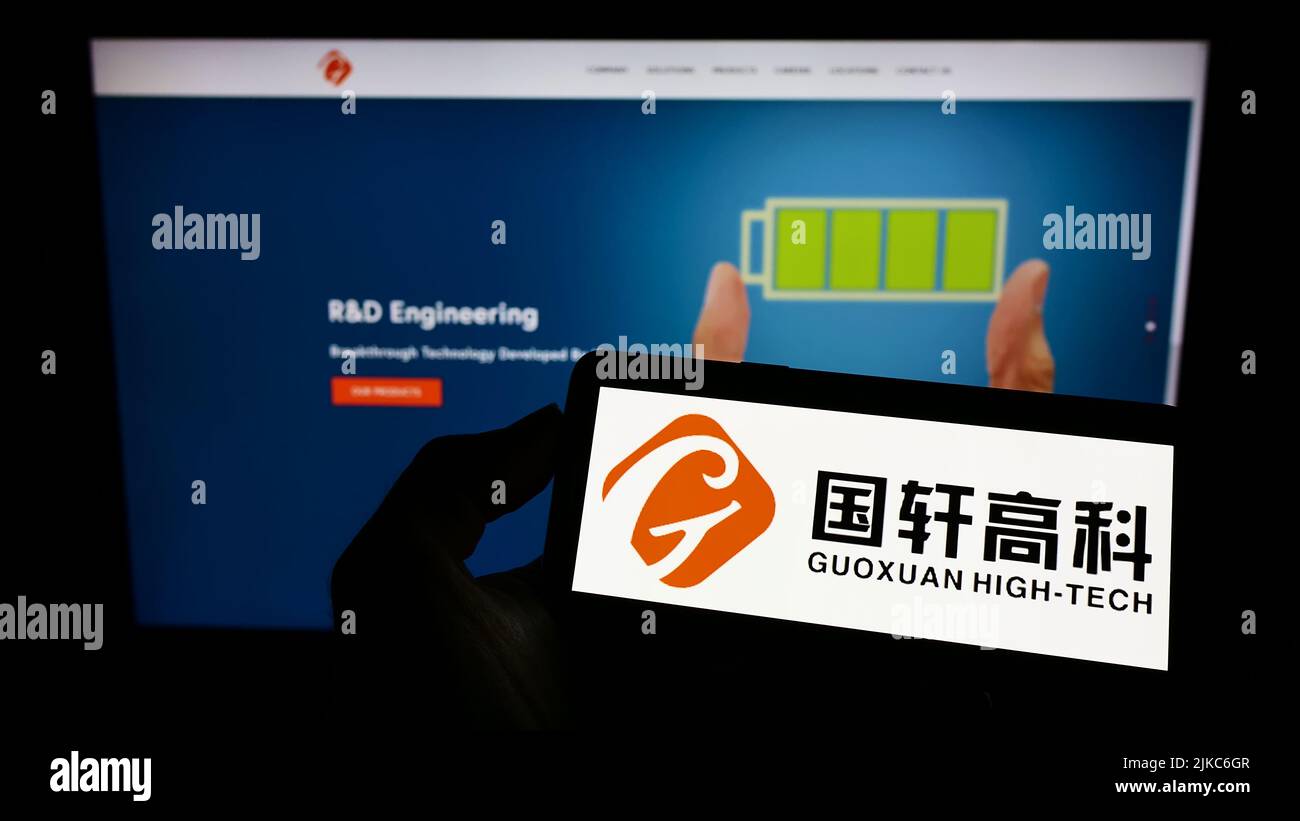 Personne tenant un téléphone portable avec le logo de la société chinoise de batterie Gotion High-Tech sur l'écran en face de la page Web d'affaires. Mise au point sur l'affichage du téléphone. Banque D'Images
