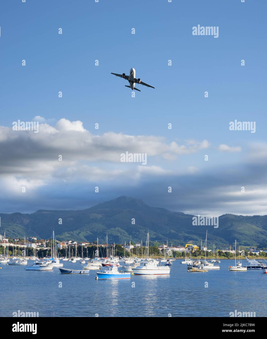 Avion survolant les navires et les montagnes en arrière-plan. Banque D'Images