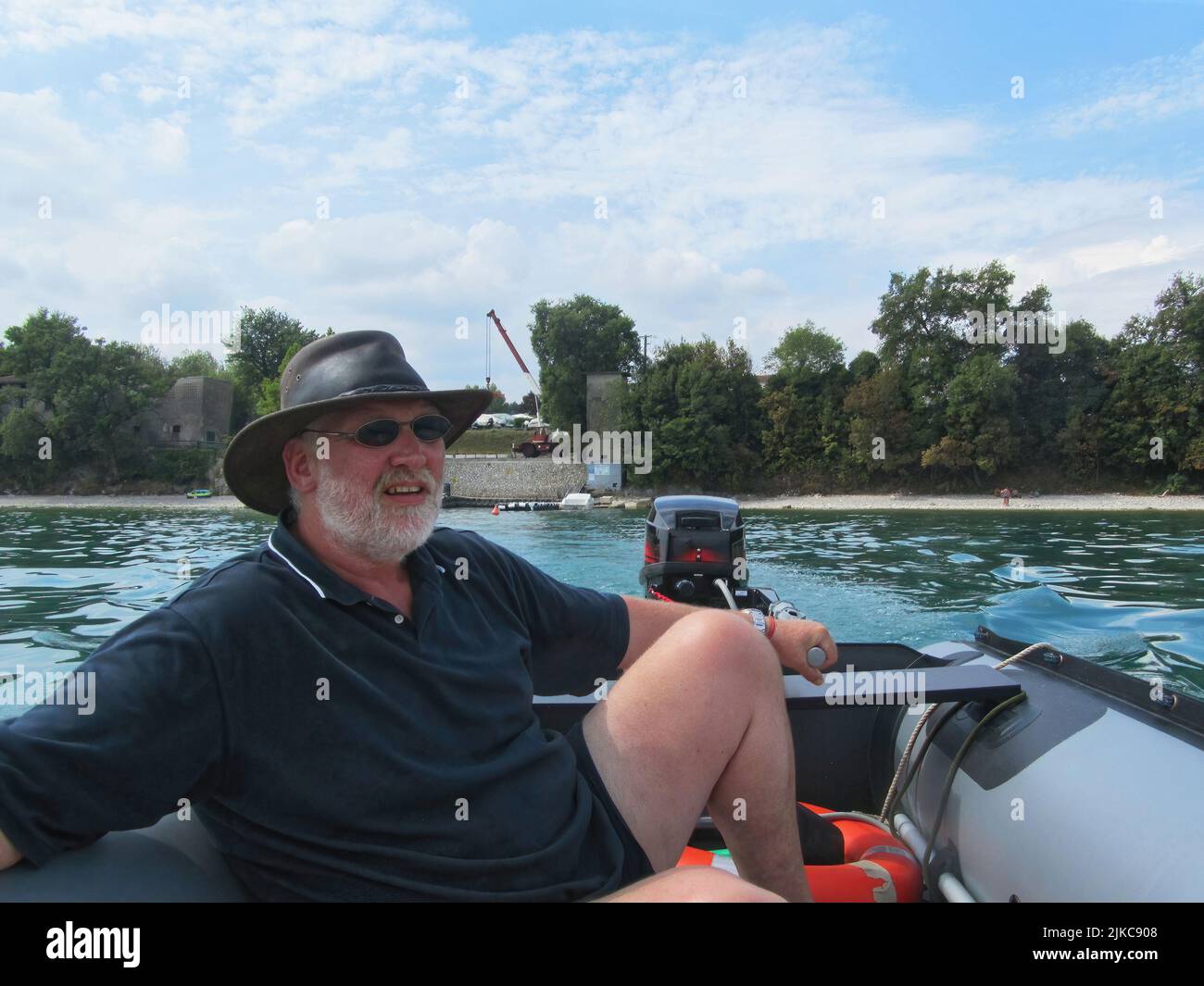 homme qui fait le tour d'un bateau gonflable sur un lac Banque D'Images