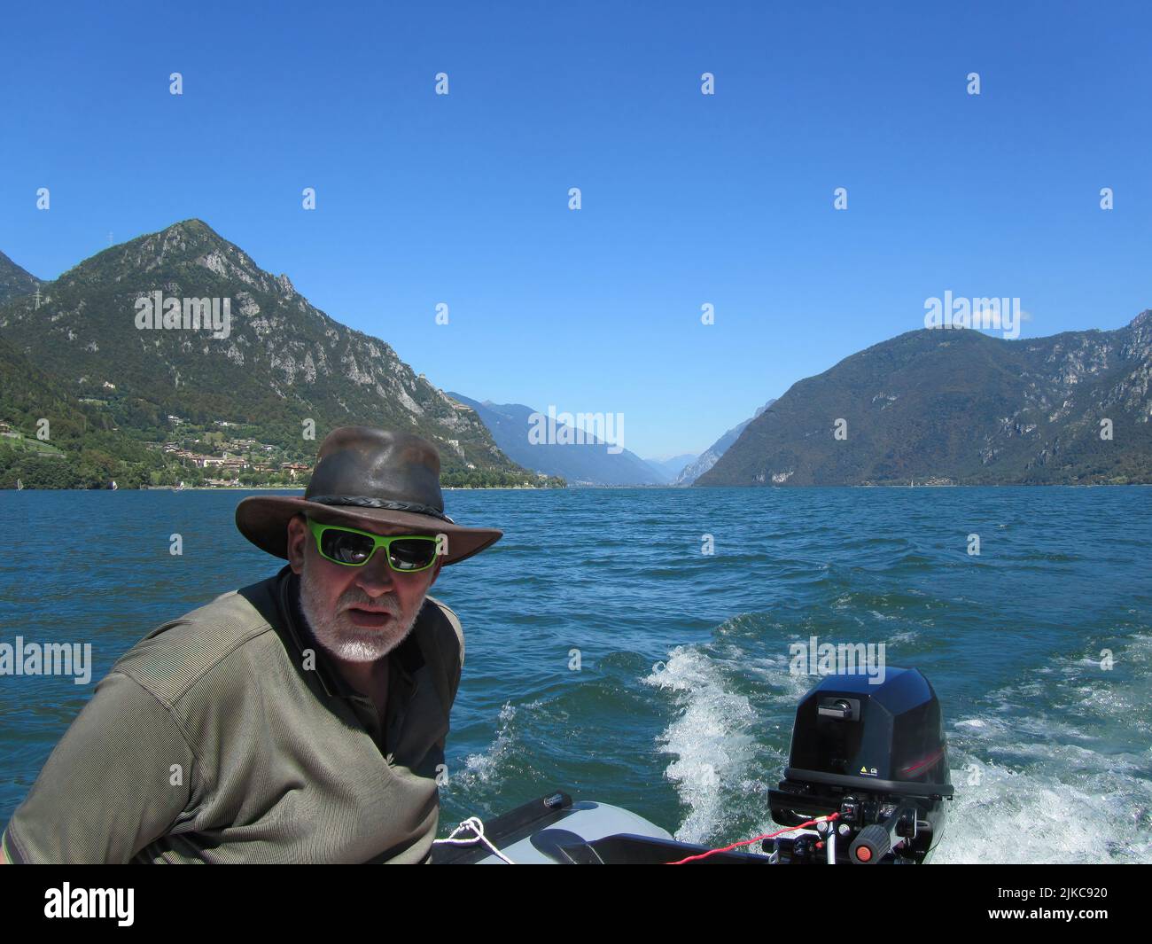 homme conduisant un bateau sur un lac dans les montagnes Banque D'Images