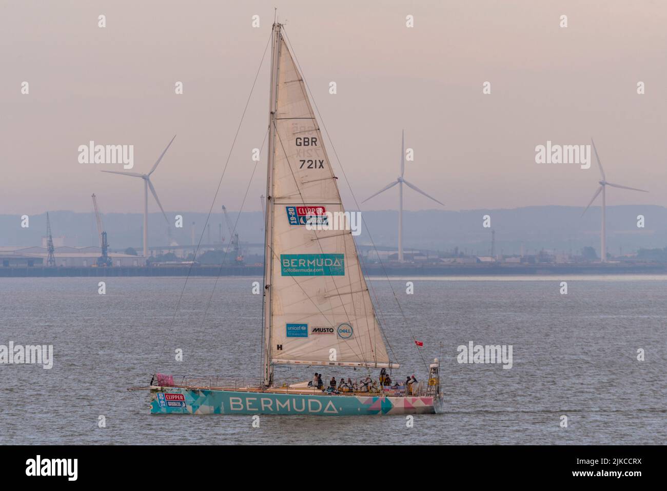 L'équipe des Bermudes yacht à l'aube au large de Southend Pier dans l'estuaire de la Tamise après avoir terminé la course de yacht Clipper Round the World. Parc éolien énergie éolienne Banque D'Images