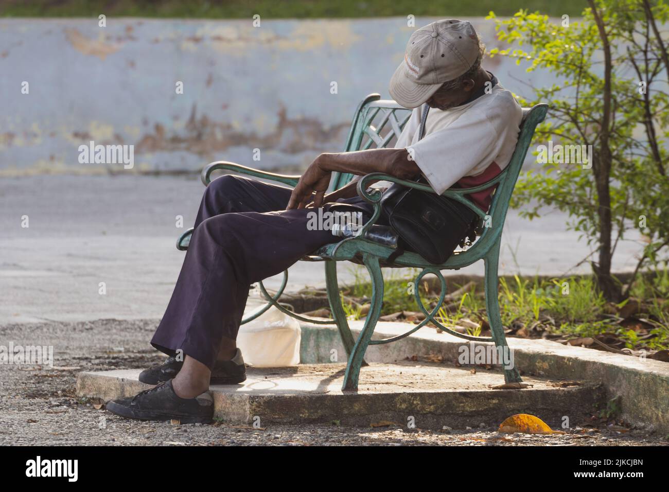 Un gros plan d'un homme dormant assis sur le banc extérieur à Matanzas, Cuba Banque D'Images
