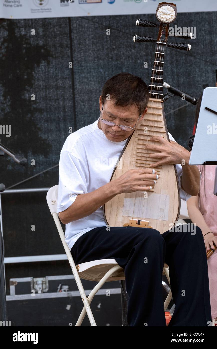 Un membre de l'ensemble de musique chinoise de New York joue la pipa, un instrument chinois traditionnel. Au Hong Kong Dragon Boat Fest à Queens, New York. Banque D'Images