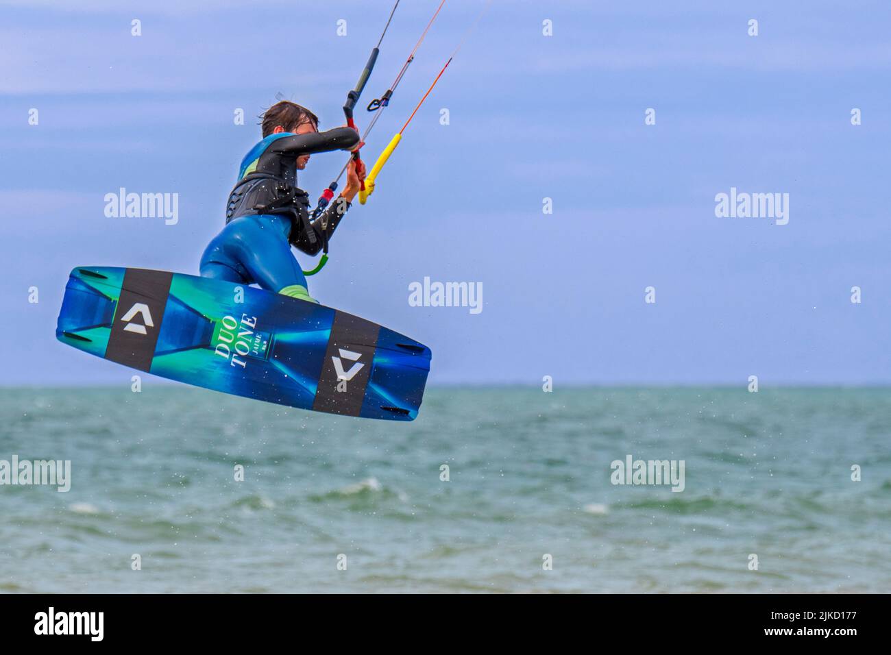 Kitesurf montrant kiteboarder / kitesurfer sur le twintip jumping sur la mer du Nord par une journée venteuse Banque D'Images