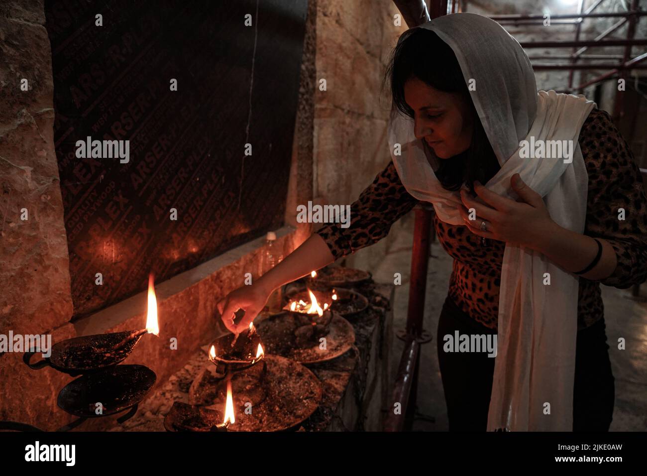 Lalish, Irak. 01st août 2022. Une femme éclaire un feu à l'intérieur du sanctuaire de Shekadi tandis que Yazidis célèbre l'été Arbaeen Eid (le 40th de l'été) en se rassemblant au temple de Lalish pour commémorer les vacances et pratiquer ses rituels. Le festival est semblable d'une certaine manière à l'Eid al-Fitr du musulman, car il commence après les religieux, et ceux qui peuvent du grand public ont jeûné pendant quarante jours. Credit: Ismael Adnan/dpa/Alay Live News Banque D'Images