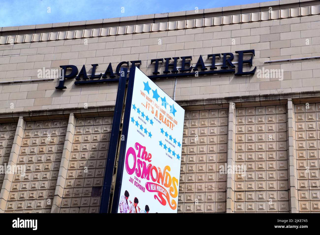 Vue extérieure de la façade du Palace Theatre, Oxford Street, Manchester, Angleterre, Royaume-Uni. Un panneau publicitaire annonce la comédie musicale Osmonds. Banque D'Images