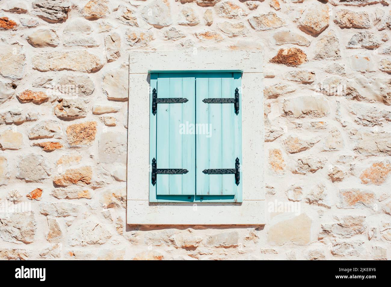 Volets de fenêtre bleu clair fermés dans un mur en pierre. Banque D'Images