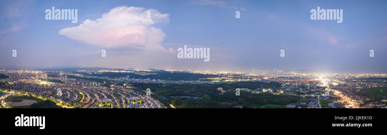 Vue panoramique d'un seul nuage sur un paysage urbain tentaculaire la nuit Banque D'Images