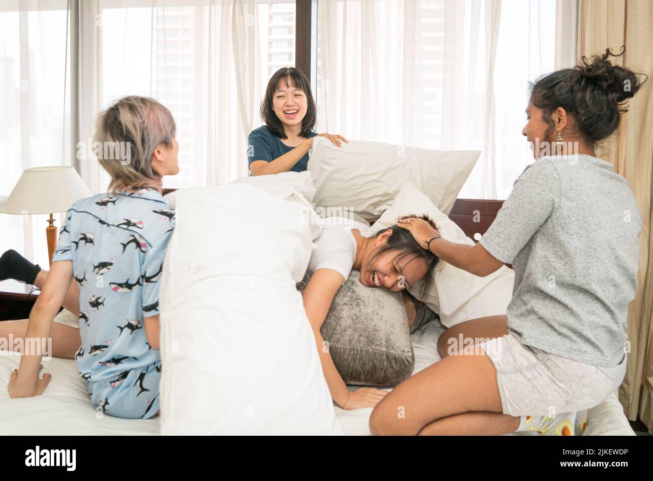 Multi-ethnique filles oreiller lutte dans la chambre, dormir sur le concept de partie. Banque D'Images