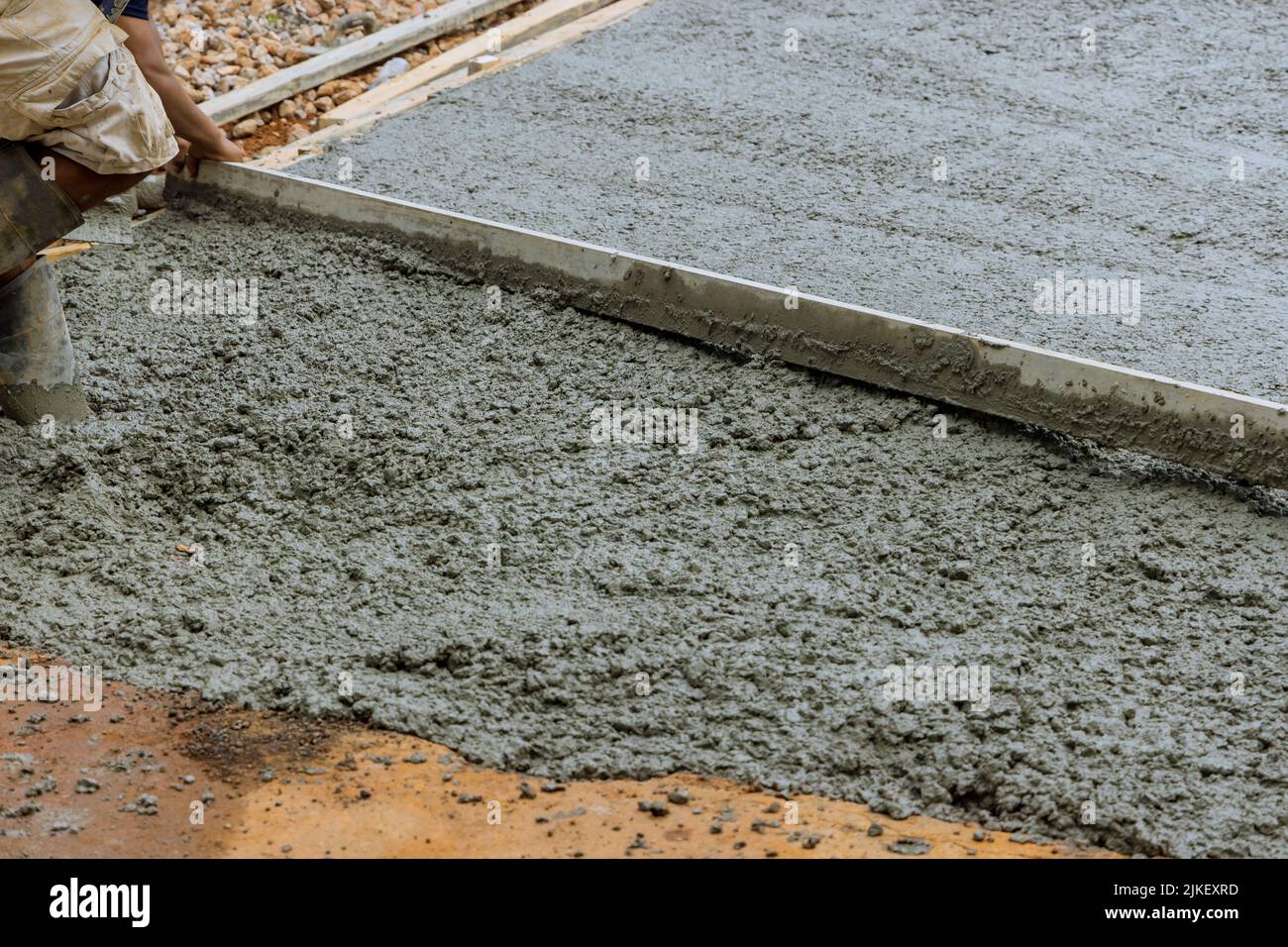 Travailler à verser du ciment une nouvelle allée en béton dans une maison résidentielle Banque D'Images