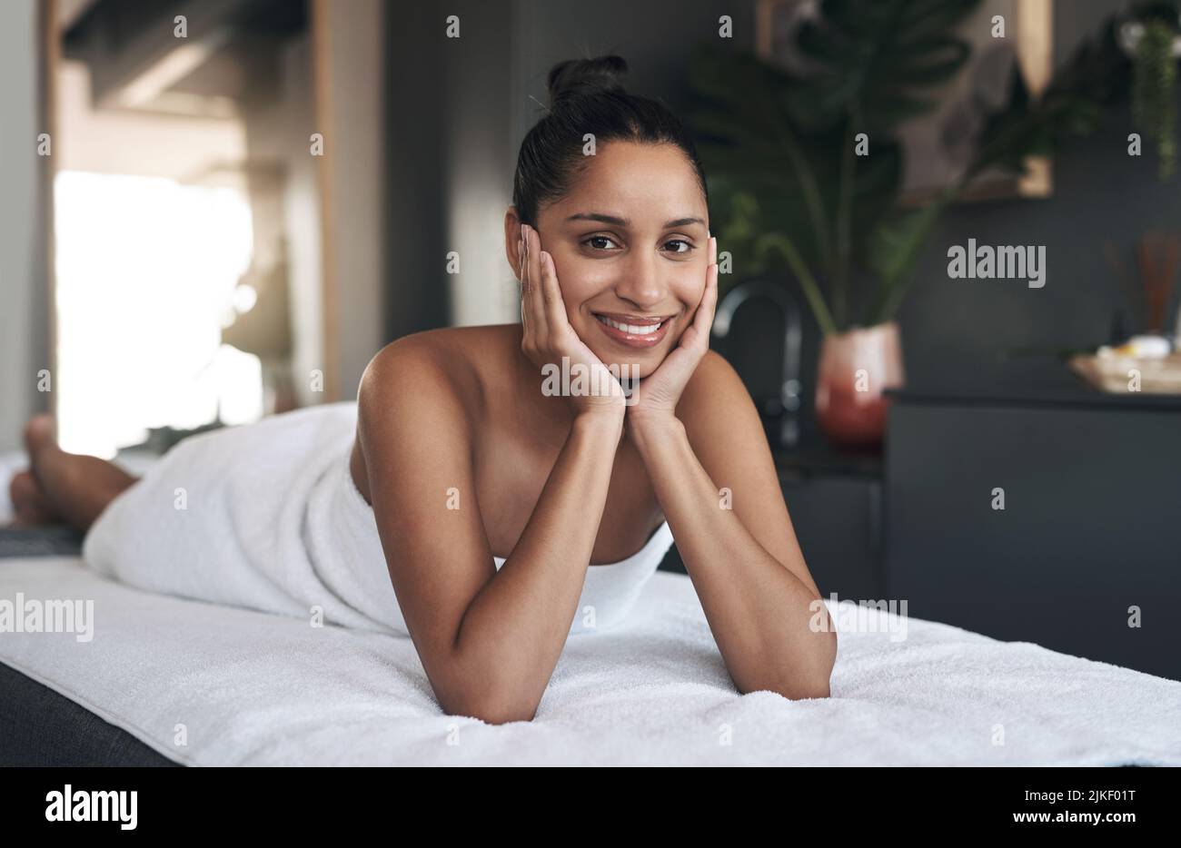 De loin, c'est le meilleur spa. Portrait d'une jeune femme se relaxant sur un lit de massage dans un spa. Banque D'Images